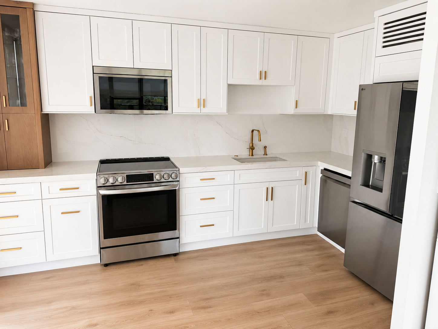 Bayshore Apt Renovation — finished kitchen with white shaker cabinetry, marble backsplash and brass fixtures